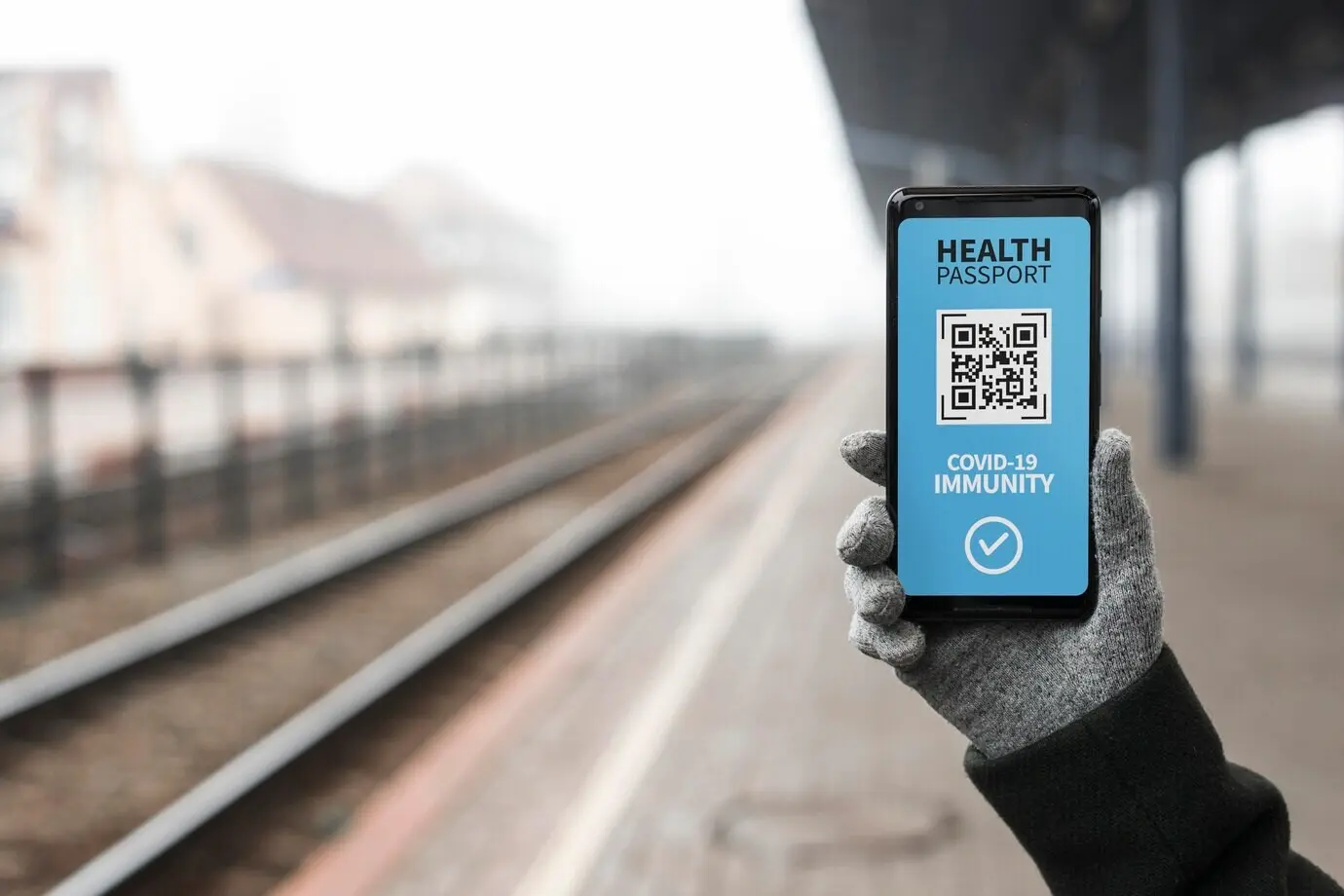 Vorderansicht einer Person, die einen virtuellen Gesundheitspass auf einem Smartphone hält